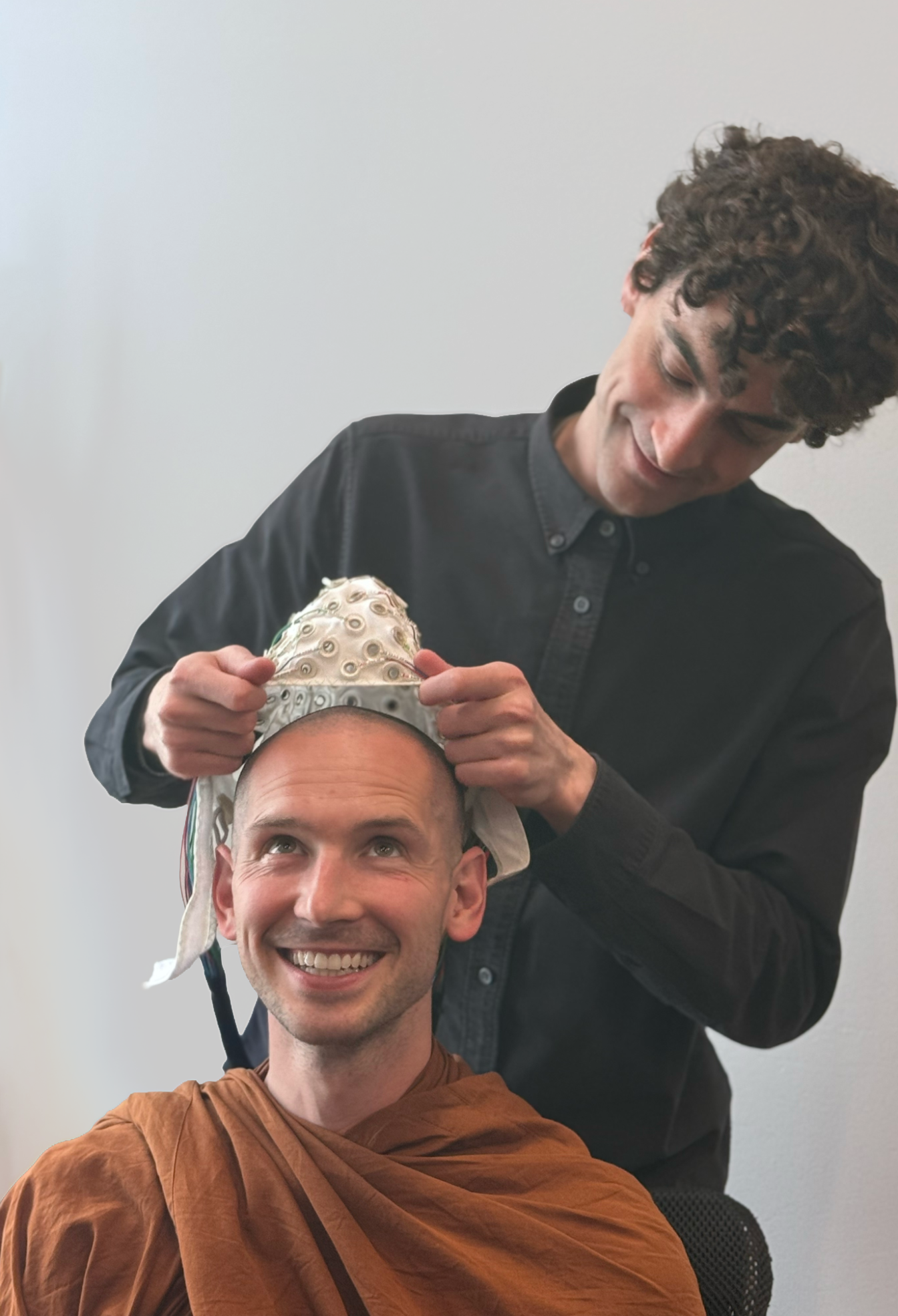 A Meditation Research Program researcher fitting an EEG cap on a meditating practitioner